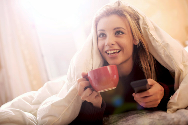 woman watching tv in bed